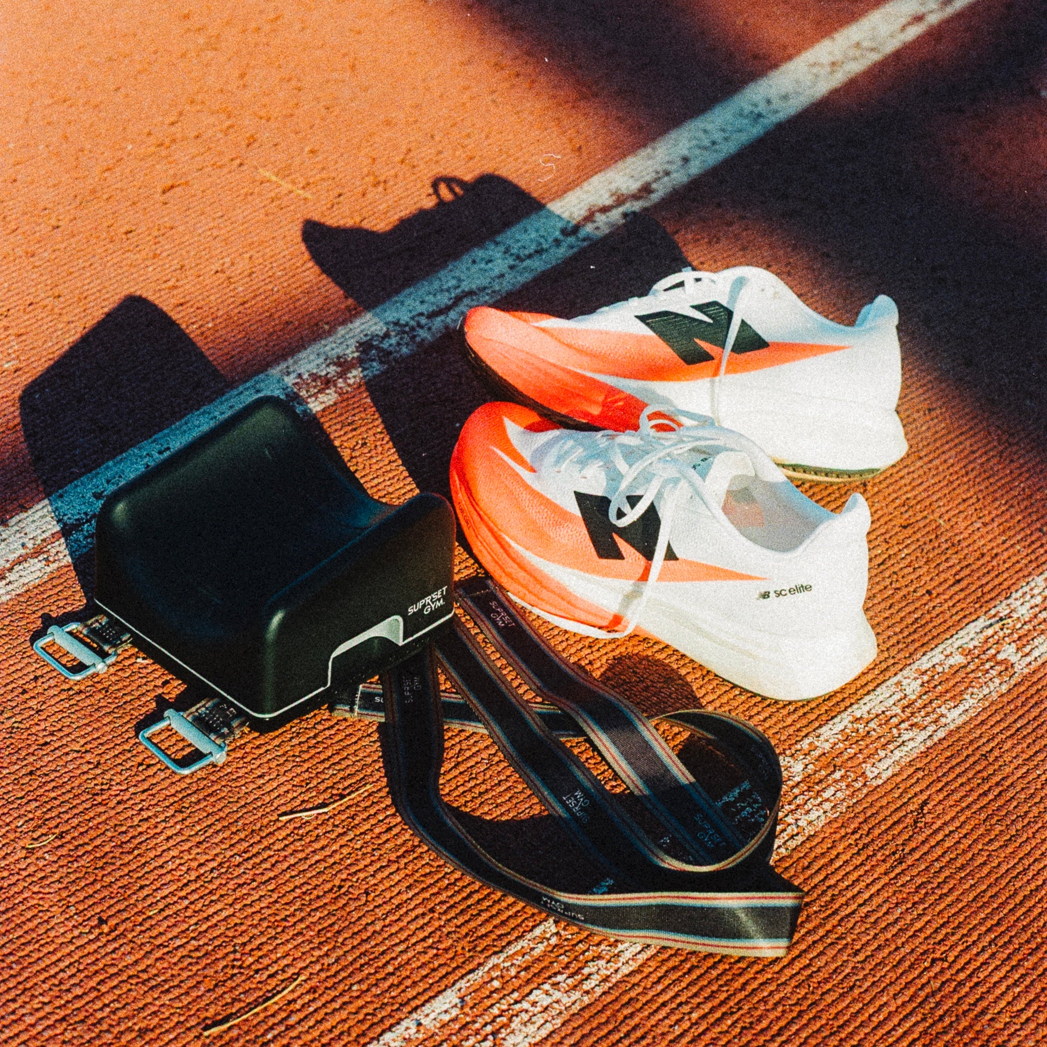 Bulgarian Stability block with pair of white and orange running shoes on a track.